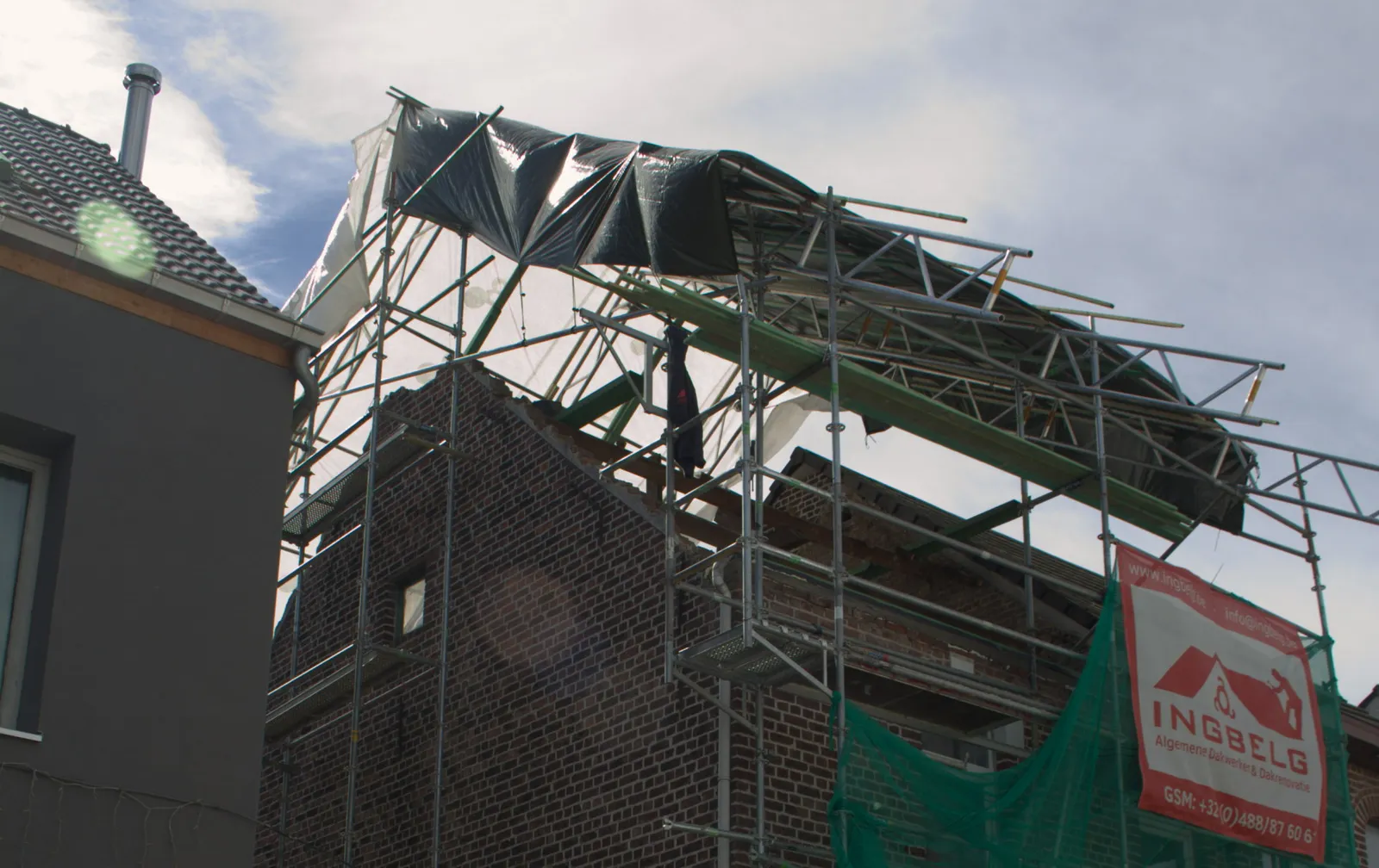 Tijdelijk dak van INGBELG boven een open dak, opgebouwd op steigers en afgedekt met zeil