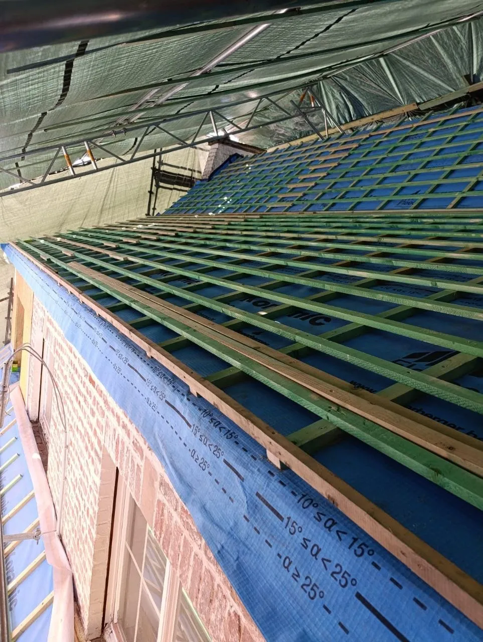 De steigerconstructie van het tijdelijk dak boven het open dakvlak met onderdak
