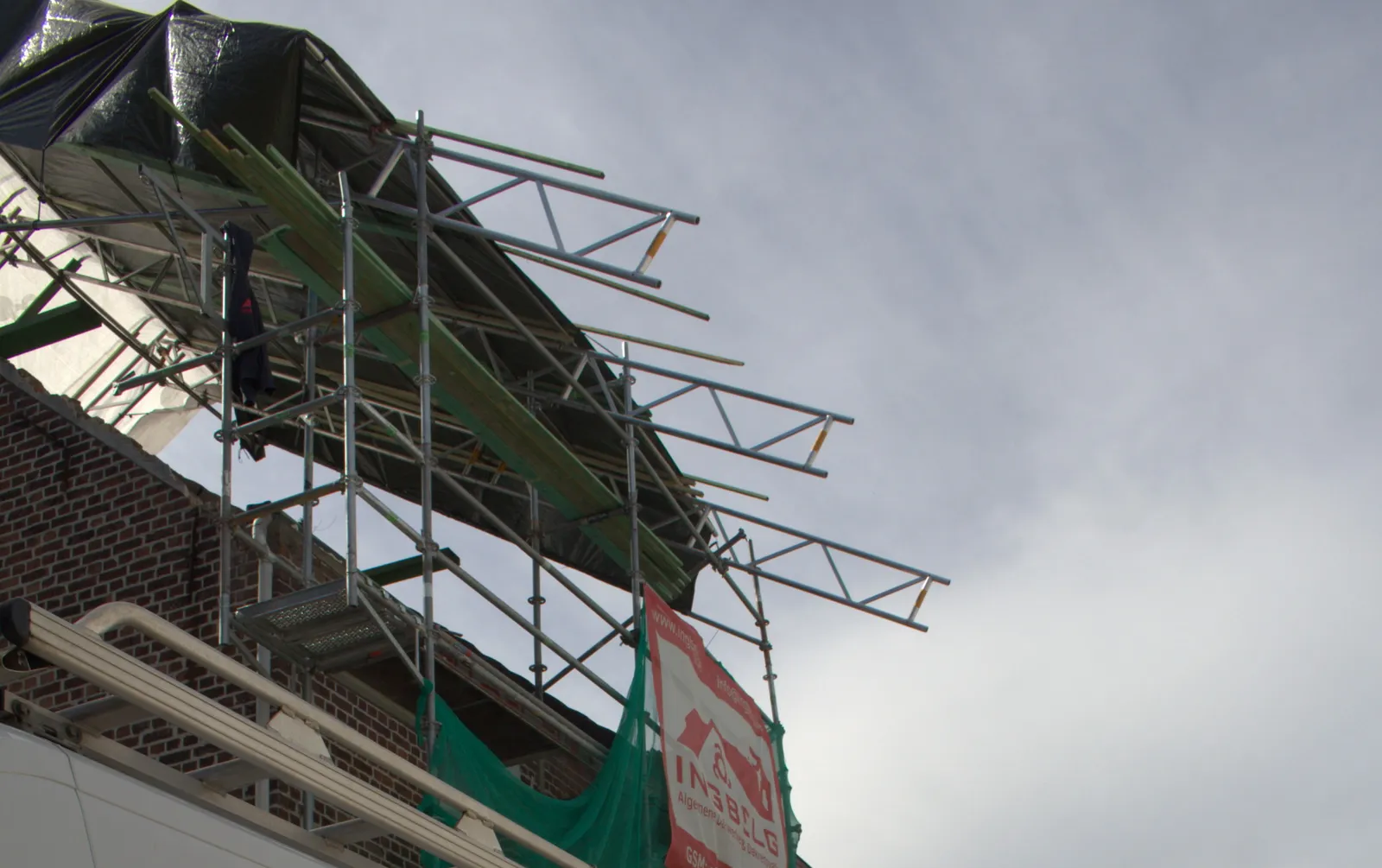 Onderzijde van het tijdelijk dak: liggers en steigerconstructie onder het zeil