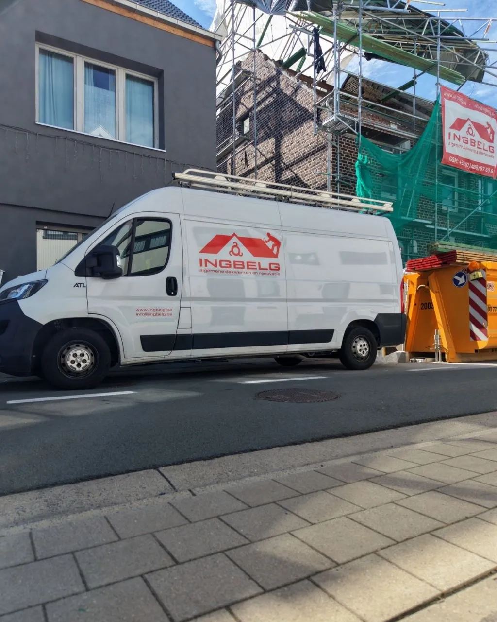 INGBELG-bedrijfswagen voor een werf met steiger en tijdelijk dak